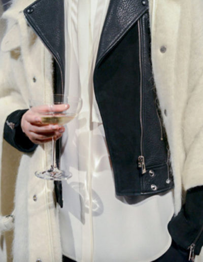 a model holds a glass of champagne during a london fashion week presentation