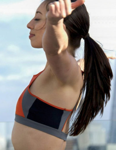 a woman in workout kit stretches on a london rooftop during a product photography shoot by surrey social stock photography