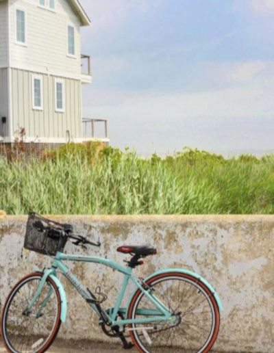 a pastel bike leaning against the wall in the hamptons