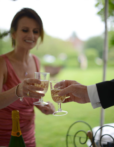 a couple in evening wear toast at a picnic during a lifestyle photography shoot in surrey