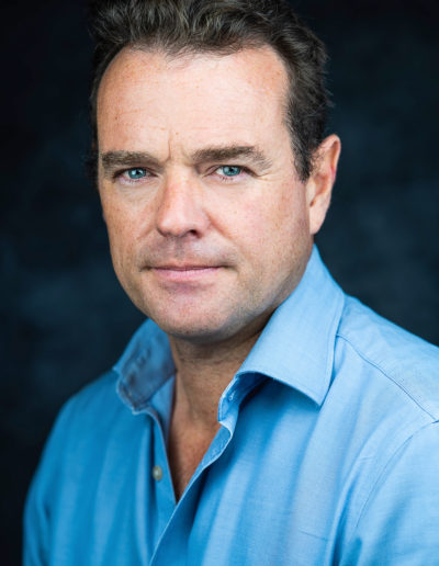 a man with blue eyes and blue shirt poses for a headshot photograph with surrey headshot photographers surrey social stock photography