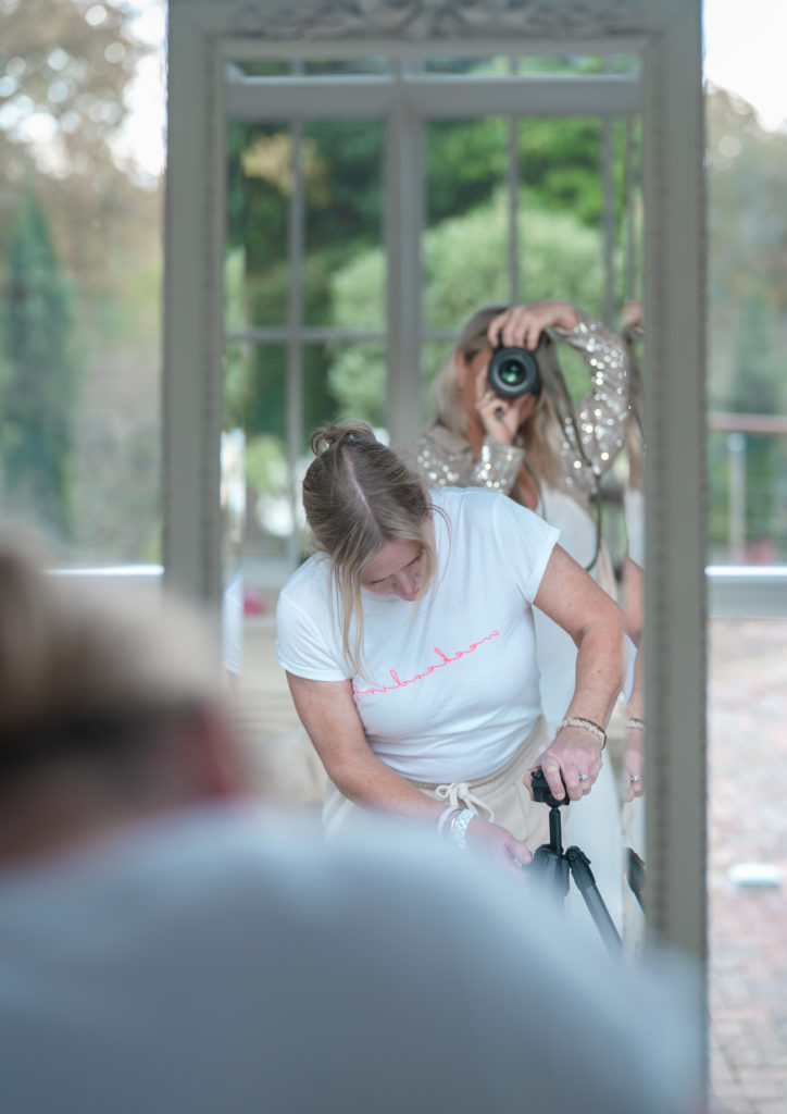 a photographer capture an image of a woman setting up a tripod photographed by business photographers surrey social stock photography.