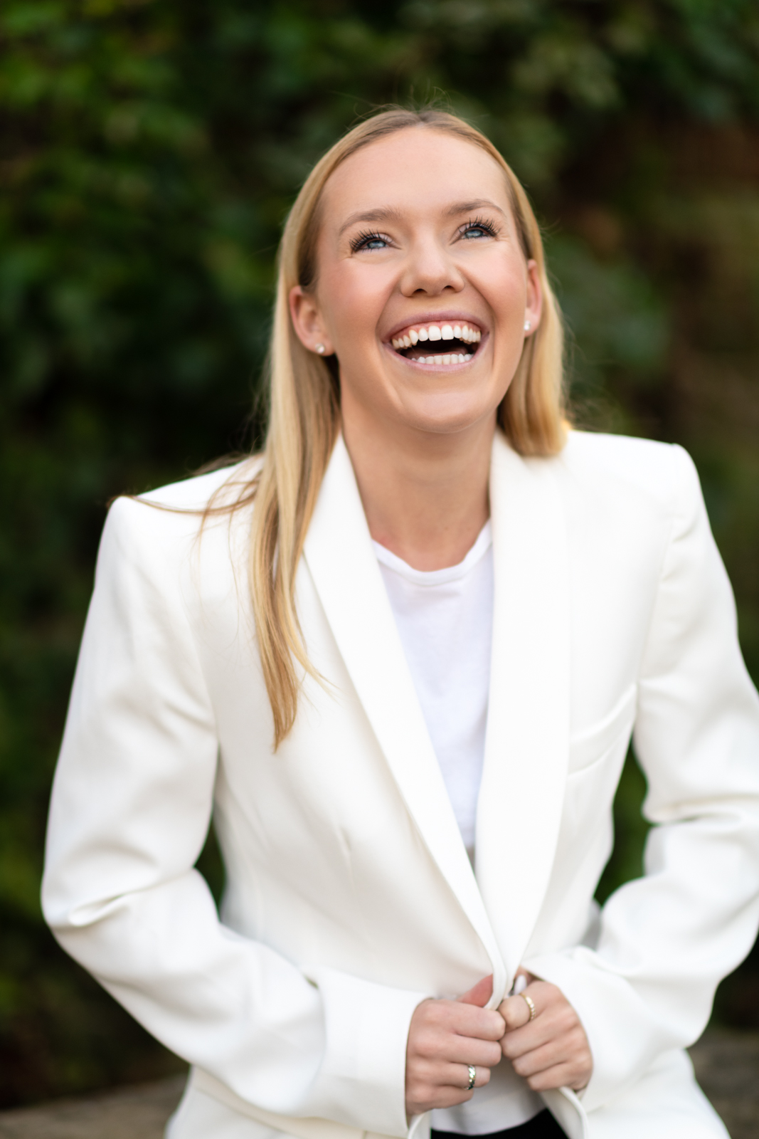 young woman in a white jacket laughs during a headshot shoot with surrey social stock photography
