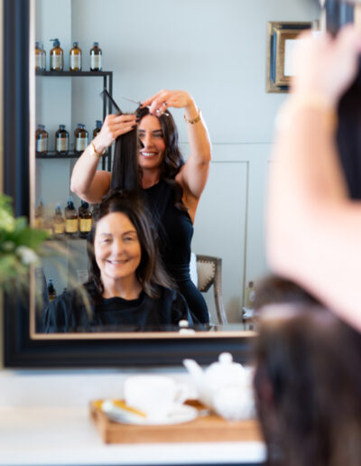a hair dresser cutting a client's hair during a personal brand photo shoot