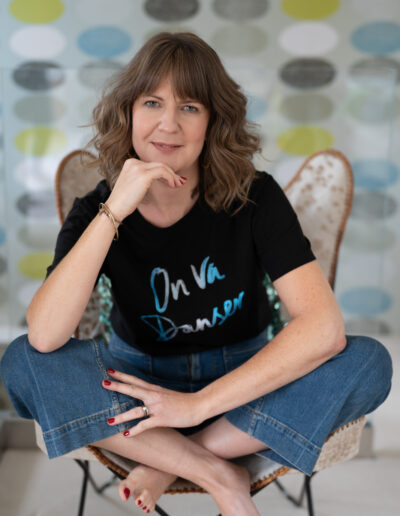a woman sits on a chair cross legged