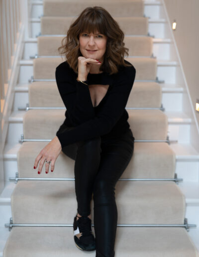 a woman sits on the stairs for a photo shoot