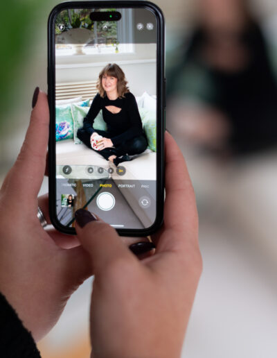 a woman takes a picture of a musician with her iphone