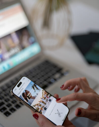 a woman works at her desk whilst using her iphone