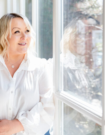 a woman gazes out of a large window