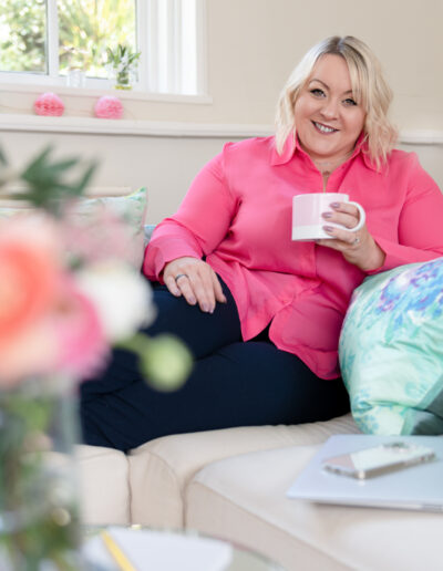 a woman sits on the sofa with a coffee