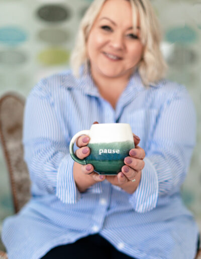 a woman holds forward a mug of tea during a personal brand photo shoot in surrey
