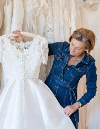 a wedding dress designer holding a wedding gown during a photo shoot with surrey social stock photography