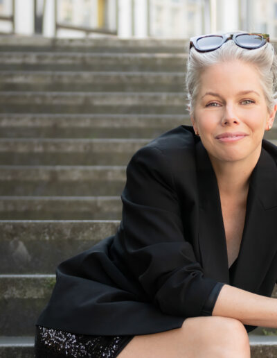 a woman poses on some steps during a personal brand photo shoot in surrey