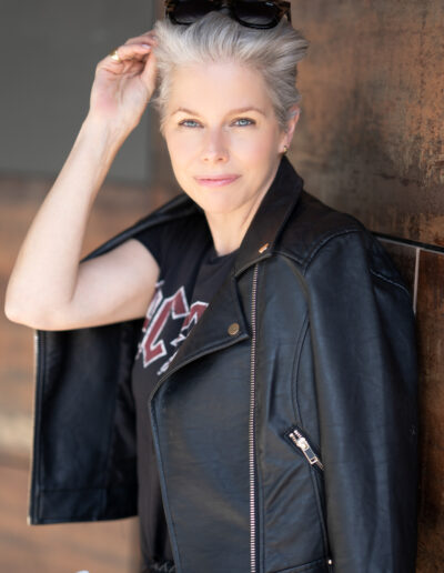 a woman wearing a leather jacket poses for a personal brand photo shoot in guildford