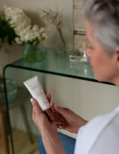 a woman holds her skincare product during a personal brand photo shoot in surrey
