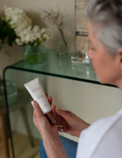 a woman holds her skincare product during a personal brand photo shoot in surrey