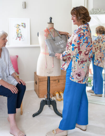 a stylist helps her client choose a bag during a personal brand photo shoot in surrey