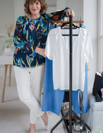 a stylist leans against a rack of clothes during a personal brand photo shoot in surrey