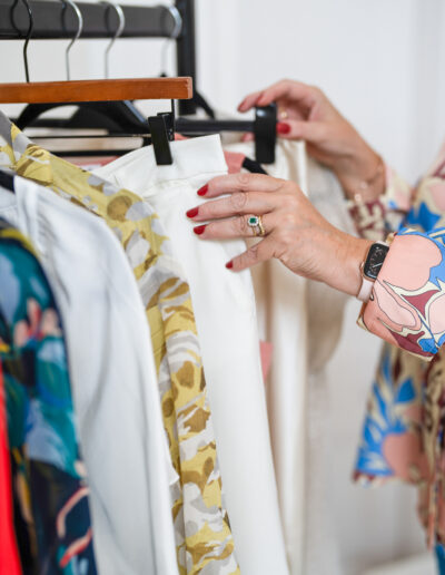 a stylist looks through a rack of clothes during a personal brand photo shoot in surrey