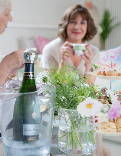 two women sharing champagne and afternoon tea during a personal brand photo shoot in surrey