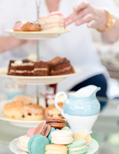 a woman picks a cake from a stand during a personal brand photo shoot in surrey