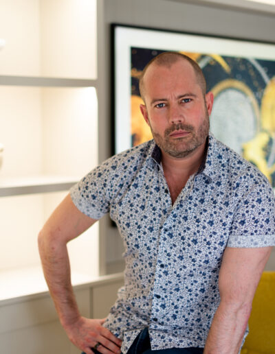 a man leans against a table during a personal brand photo shoot in surrey