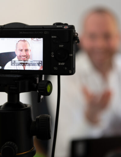 a man recording a video at his work desk during a personal brand photo shoot in surrey