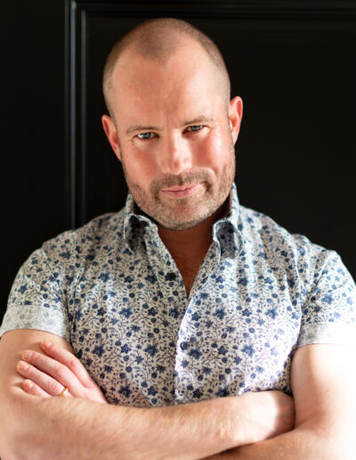 a man with folded arms stares at the camera during a personal brand photo shoot in surrey